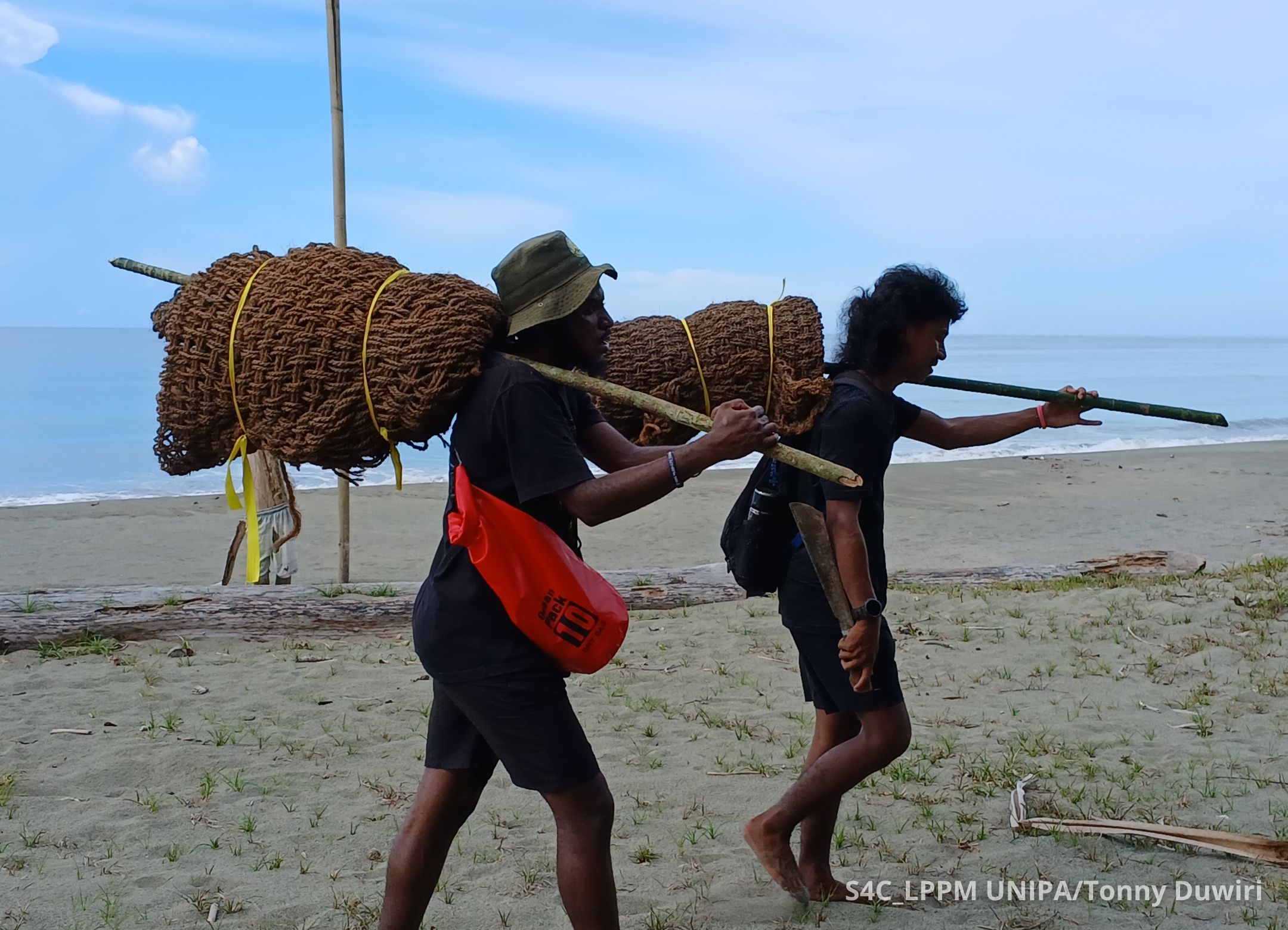 Brian dan anggota tim lainnya sedang mengangkat gulungan cocomesh untuk perlindungan sarang_Foto dari Tonny Duwiri.jpg